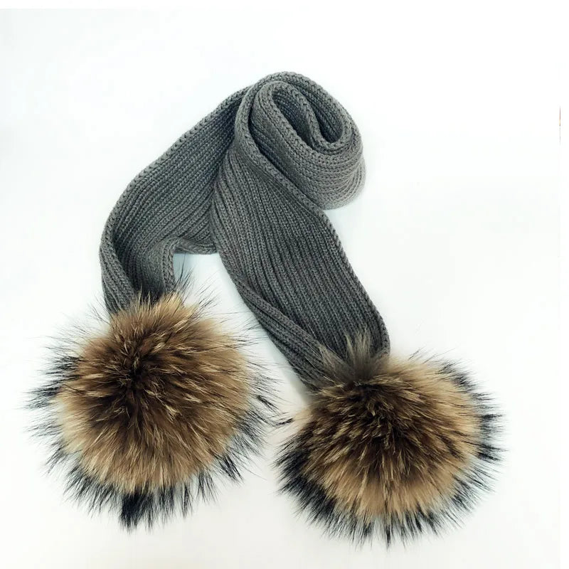 Thin scarf with fur pom moms on the ends. Available in a variety of colors.